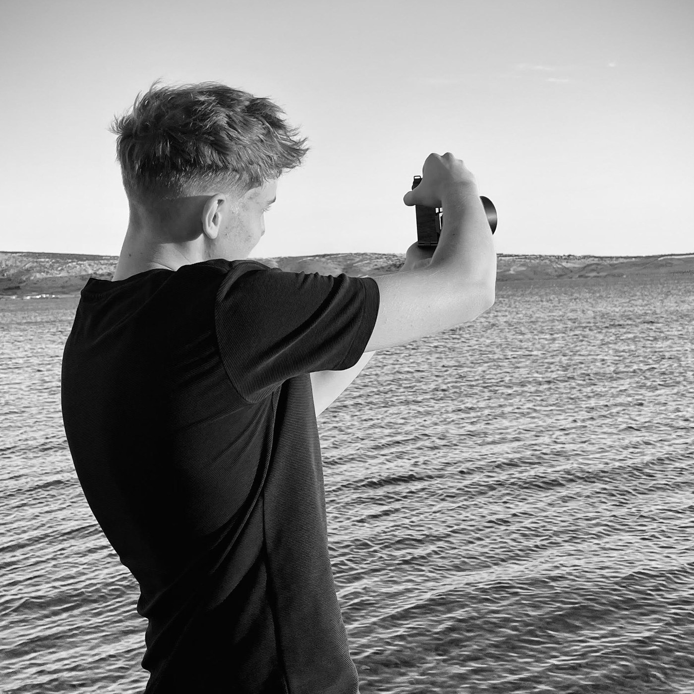 Tai Oprešnik med fotografiranjem ob vodi
